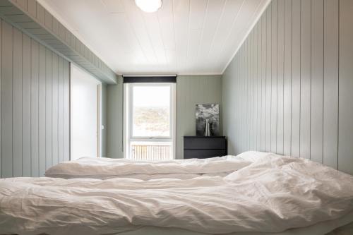 バルスタにあるSeaside apartment in Ballstadのベッドルーム1室(白いベッド2台、窓付)