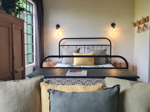 a bedroom with a bed with pillows on it at Little Fields Country House and Cottages in Howick