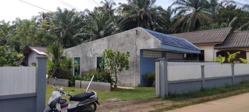 ein Motorrad, das vor einem Haus geparkt ist in der Unterkunft GreeneryHouseKrabi52 in Ban Chong Phli