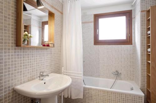 een badkamer met een wastafel, een bad en een spiegel bij Locappart Giudecca in Venetië