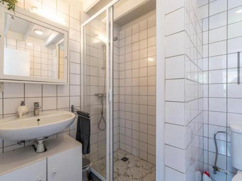 a white bathroom with a sink and a shower at Boshuisje Rekem Charly in Lanaken