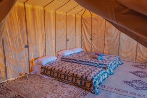a couple of beds in a tent at Silent Camp in Mhamid