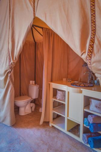 a bathroom with a toilet and a sink in a tent at Silent Camp in Mhamid