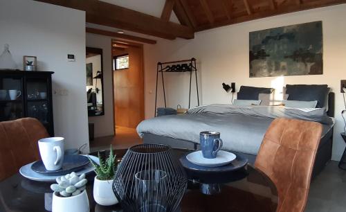 a bedroom with a bed and a table and chairs at Sjiek Basiliek in Oudenbosch