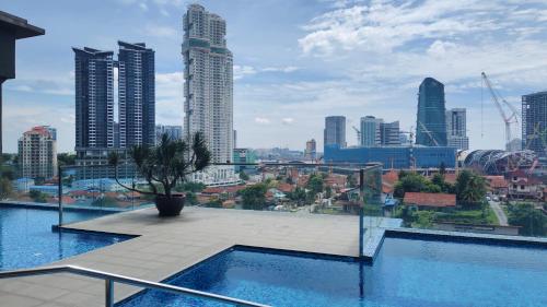 a swimming pool on the roof of a building with a city at SKS Pavillion Residences in Johor Bahru
