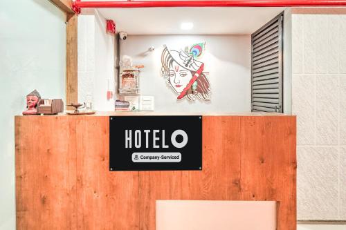 a sign for a hotel on top of a wooden door at Super Hotel O Sneh Rashmi Botanical Garden Surat Formerly Stadium Plaza in Bhatha