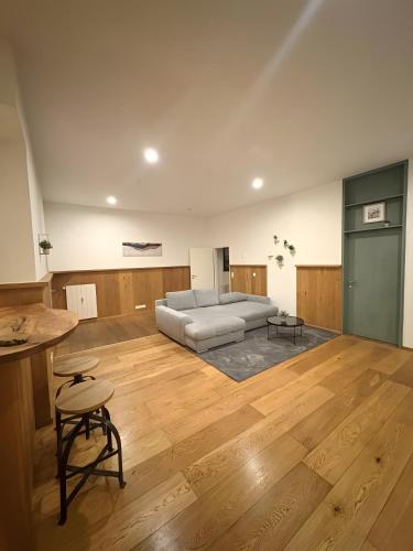 Una sala de estar con un sofá y suelo de madera. en Ferienwohnung C und D, en Oberthulba