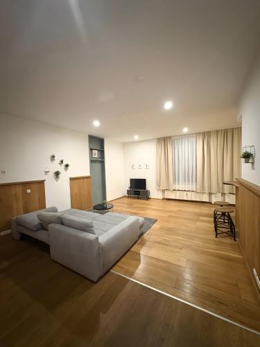 a large living room with a white couch and wooden floors at Ferienwohnung C und D in Oberthulba