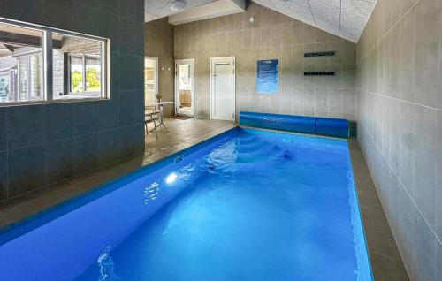 una gran piscina azul en una habitación en Awesome Home In Nørre Nebel With Sauna, en Nørre Nebel