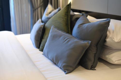 a pile of pillows sitting on a bed at KRUNA 406 Apartment in Budva