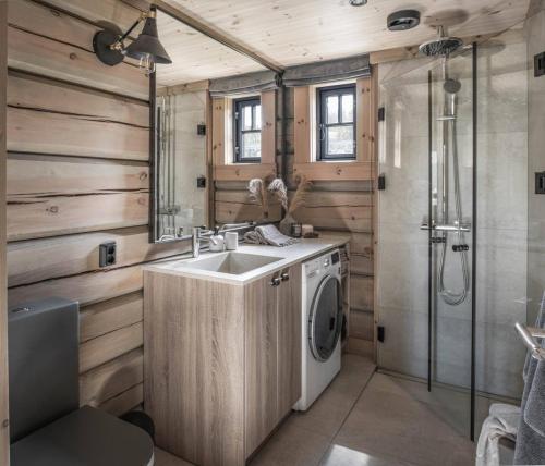 a bathroom with a sink and a washing machine at Skjonnhet Cottage - Luxury Ski-in & ski-out chalet in Kvitfjell