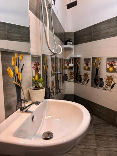 a bathroom with a sink and vases on the wall at The Kandy Look Homestay in Kandy