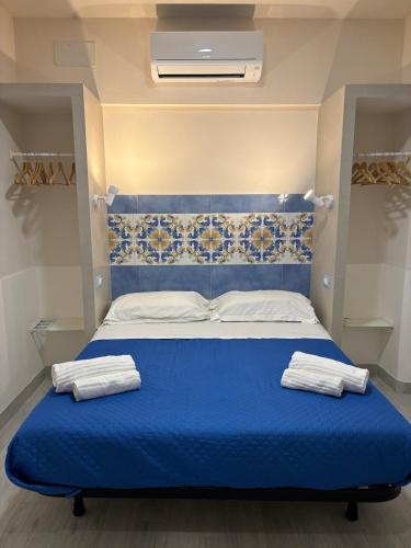 a blue bed in a room with towels on it at Vacanze a 2 passi dal mare in Giardini Naxos