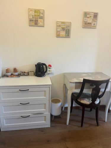a white desk with a chair and a table at SelfMatic in Orio al Serio