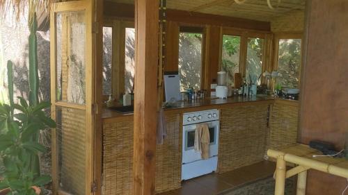 a kitchen with a stove in a room with windows at Why Nam Stunning Beach & Ocean View Jungle Penthouse in Ko Phangan