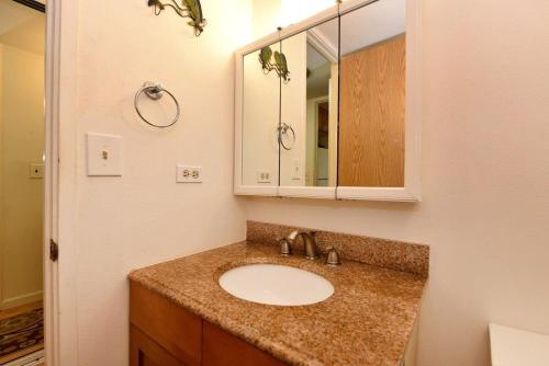 a bathroom with a sink and a mirror at Kaleialoha 402 · KA 402 Spacious Studio Close to Ocean Heated Po in Kahana