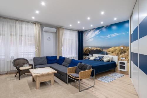 100m to Sea Beachside Studio with Private Garden & Terrace في يورمالا: غرفة معيشة مع أريكة زرقاء وطاولة