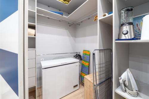 100m to Sea Beachside Studio with Private Garden & Terrace في يورمالا: مطبخ صغير مع غسالة ومجفف