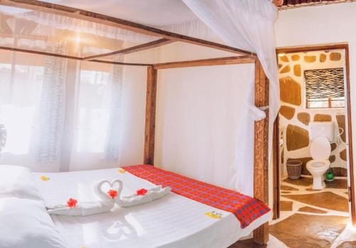 a bedroom with a white bed with a canopy at Lennana Escape in Ukunda