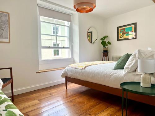 a bedroom with a bed and a window and a table at Mid-Century Gem - Heart of Frome in Frome