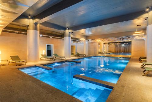 a large pool with blue water in a building at Pestana Blue Alvor Beach - All Inclusive Hotel in Alvor