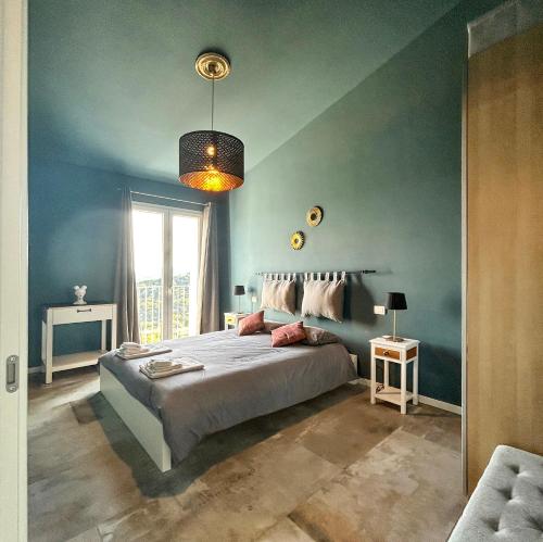 a blue bedroom with a bed and a large window at homeliday ACTIVE in Caldana