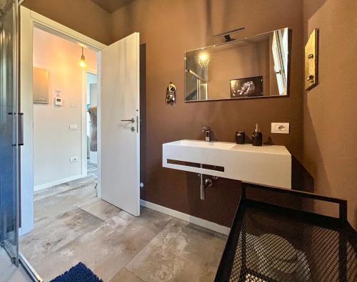 a bathroom with a white sink and a mirror at homeliday ACTIVE in Caldana