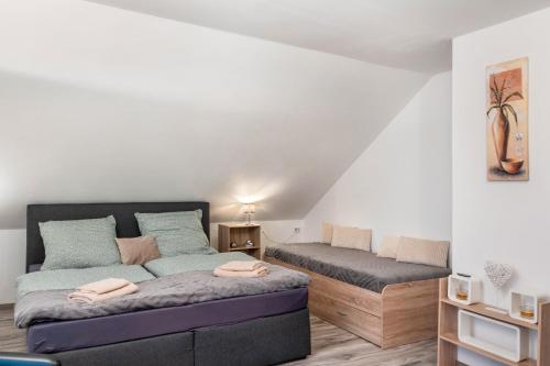 a bedroom with a bed and a couch in it at Fewo Wilhelmshaven Langewerth in Roffhausen