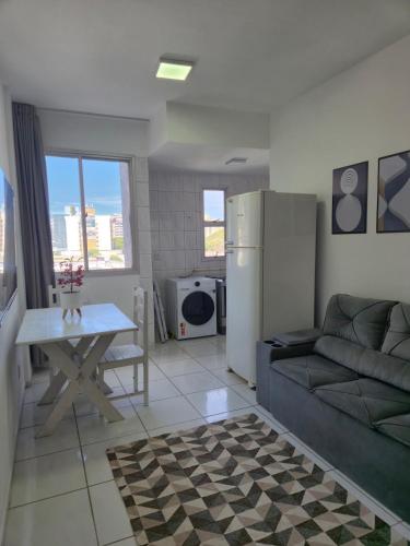 a living room with a couch and a refrigerator at Flat quarto e sala completo in Vitória
