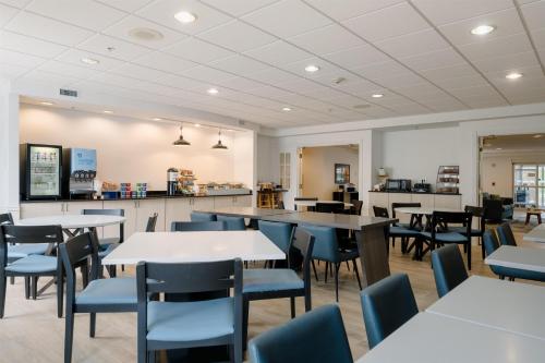 a dining room with tables and blue chairs at Hotel Bethany Beach in Bethany Beach