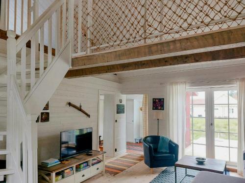 a living room with a tv and a staircase at Magical Barn Near The Sea in Ytterby
