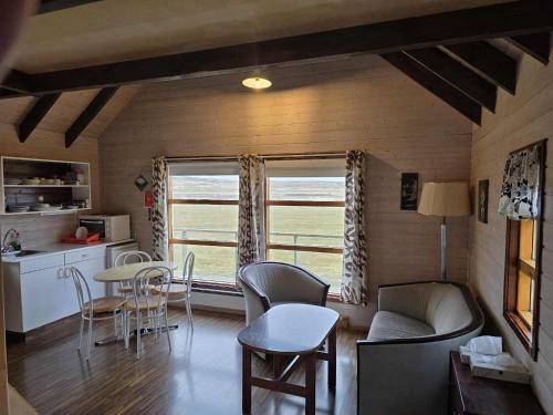 a living room with a table and chairs and a window at Dæli Apartments in Víðidalstunga