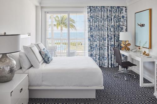 ein Schlafzimmer mit Bett, Schreibtisch und Fenster in der Unterkunft Isla Bella Beach Resort & Spa - Florida Keys in Marathon