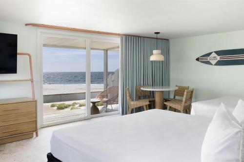 a bedroom with a bed and a view of the ocean at Riviera Beach Resort in South Yarmouth