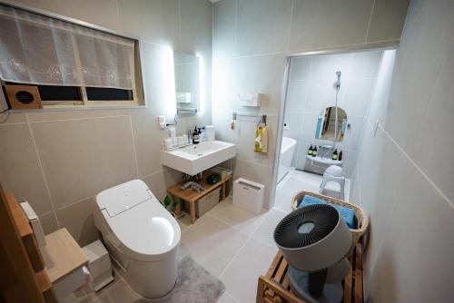 ein kleines Badezimmer mit Toilette und Waschbecken in der Unterkunft Ittokasi Ao no Ie - Vacation STAY 44156v in Fuefuki