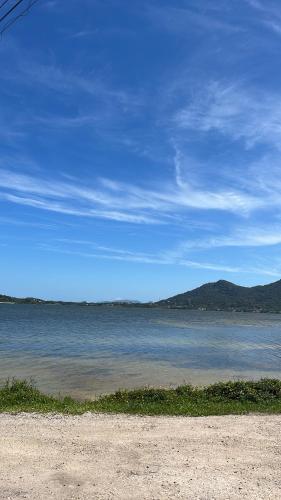 a large body of water with mountains in the background at Estúdio térreo nas margens da Lagoa in Florianópolis