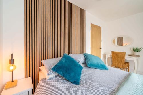 una camera da letto con un letto con cuscini blu di Coastal Corner a Woolacombe