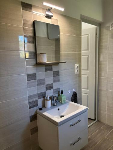 a bathroom with a sink and a mirror at Gólyafészek Vendégház in Szécsény