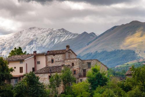 un antiguo edificio de piedra frente a una montaña en Borgofortino, en Rovitolo