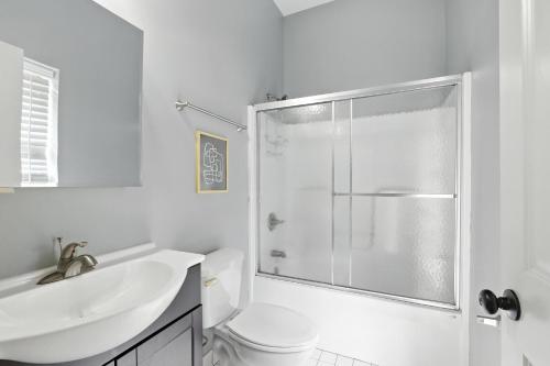 a white bathroom with a shower and a sink at NEW LISTING The Classic City Collection - 3 Separate Units in Athens