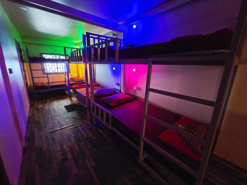 a room with two bunk beds with purple and green lights at Family Guesthouse and Hostel in Koh Rong Island