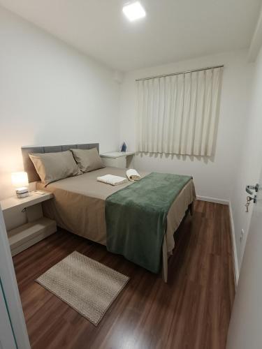 a small bedroom with a bed and a window at Apartamento Home Club, com dois quartos! in Foz do Iguaçu