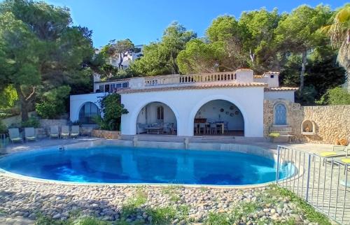 a villa with a swimming pool and a house at Unglaubliche Villa mit Meerblick und Pool in Font de Sa Cala