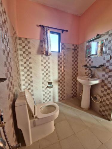 um banheiro com vaso sanitário e pia em Hotel Tree Tops- A Serene Friendly Hotel in Sauraha em Chitwan