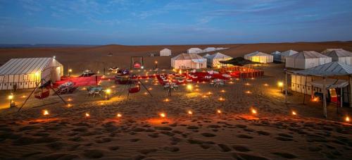 a group of tents in the desert at night at Desert tours&trips in Zagora