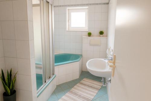 a bathroom with a tub and a sink at SUNNYHOME Monteurwohnungen und Apartments in Weiden in Moosbürg