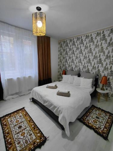 a bedroom with a large white bed and a chandelier at La Monica - Straja - Lupeni - Retezat - Parang in Lupeni