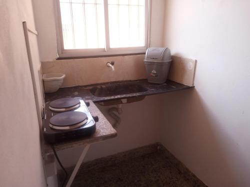 Un pequeño baño con inodoro y ventana. en Quarto São Braz, en Belém