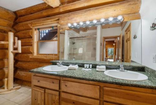 a bathroom with two sinks and a large mirror at Mashie Meadows Log Cabin in Tahoe Vista