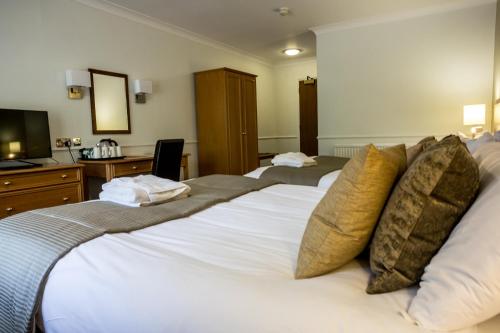 a hotel room with two beds and a television at Hellaby Hall Hotel; BW Signature Collection in Hellaby
